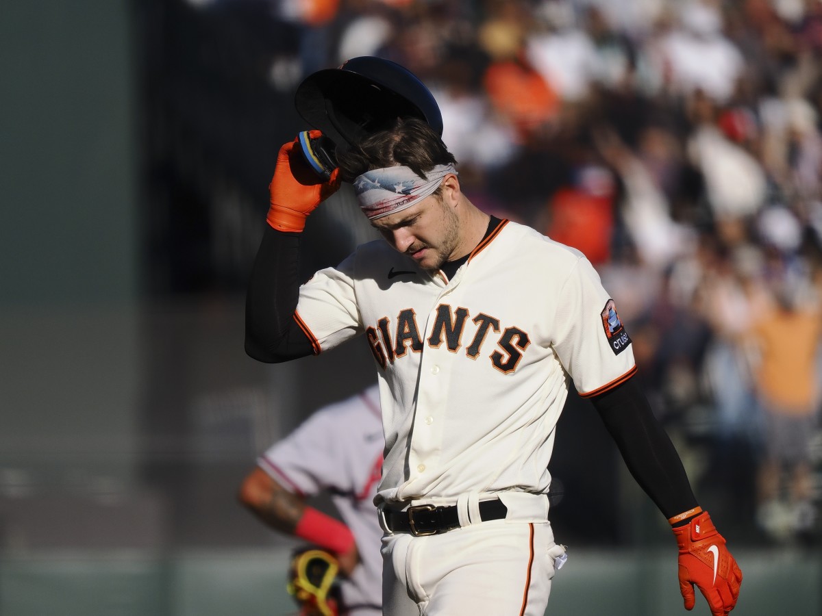 SFGiants catcher Patrick Bailey (14) removes his batting helmet after hitting a three-run RBI double against the Atlanta Braves (2023).