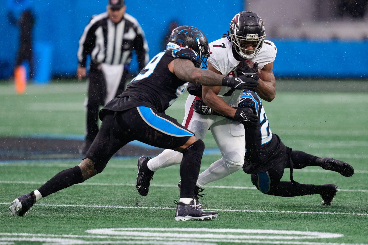 Carolina Panthers cornerback Donte Jackson (26) and linebacker Frankie Luvu (49) tackle Atlanta Falcons running back Bijan Robinson (7) during the first quarter at Bank of America Stadium.