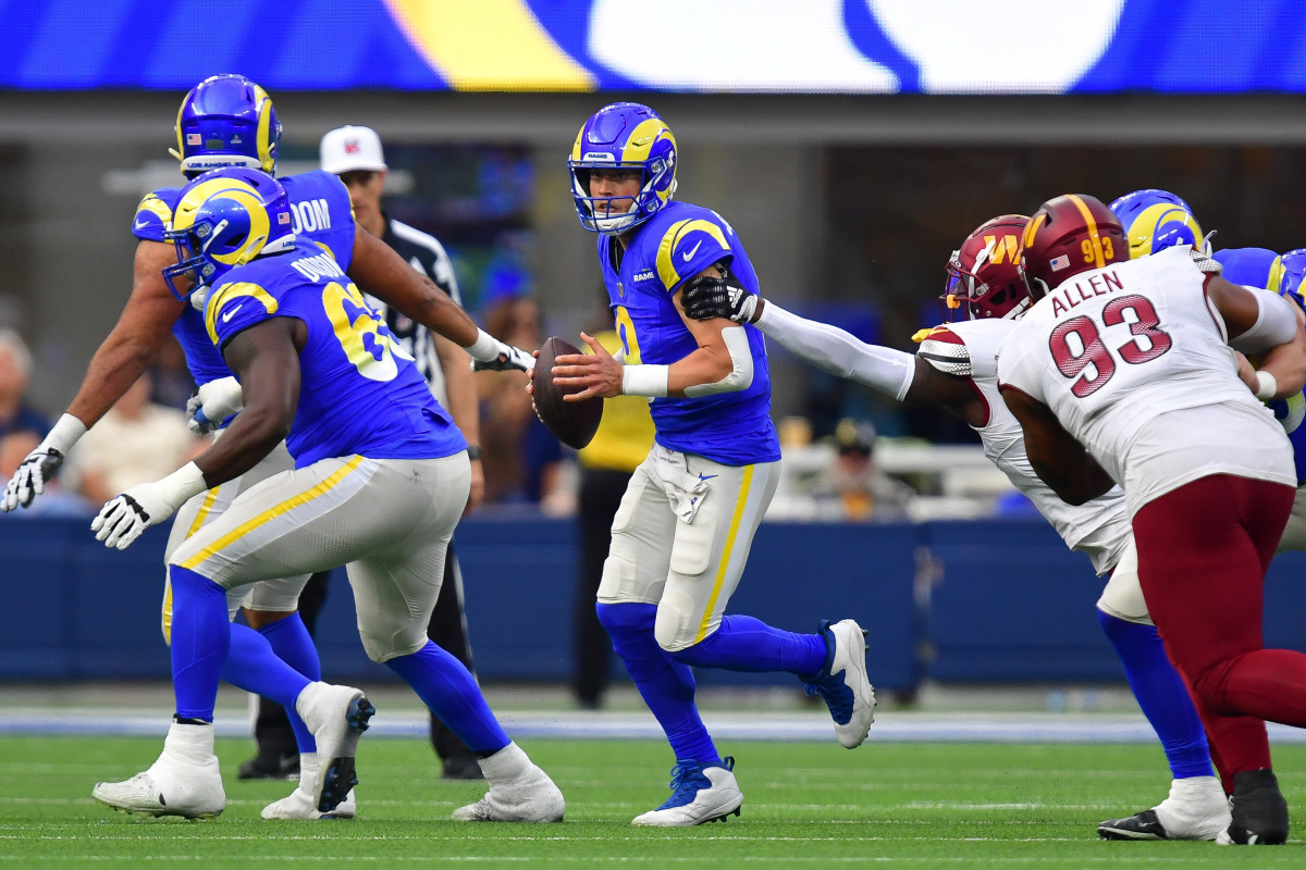 Los Angeles Rams quarterback Matthew Stafford (9) moves out to pass against the Washington Commanders during the first half at SoFi Stadium.