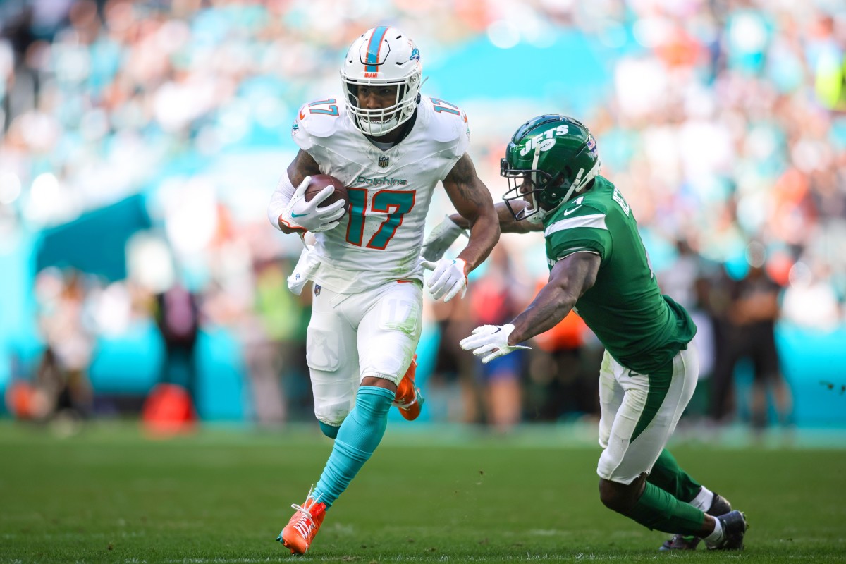 Dec 17, 2023; Miami Gardens, Florida, USA; Miami Dolphins wide receiver Jaylen Waddle (17) runs with the football past New York Jets cornerback D.J. Reed (4) during the second quarter at Hard Rock Stadium.